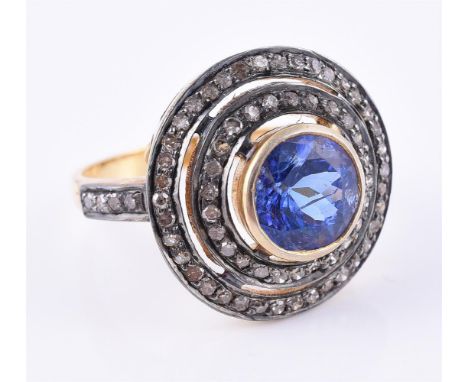 
	
		A tanzanite and diamond cluster dress ring, the central circular cut tanzanite within a double surround of eight cut dia