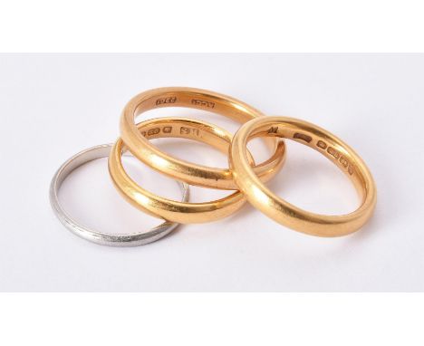 
	
		Two 22 carat gold band rings, both hallmarked Birmingham 1922, finger size M; a further gold coloured band ring stamped 