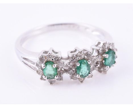 
	
		An emerald and diamond triple cluster ring, the trio of oval cut emeralds within a surround of brilliant cut diamonds, f