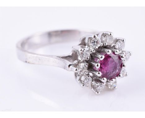 
	
		A pink sapphire and diamond cluster ring, the central circular cut pink sapphire claw set within a surround of eight cut