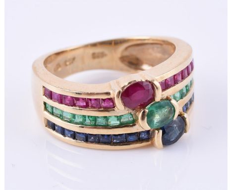 
	
		A ruby, sapphire and emerald triple row ring, set with oval mixed cut and square cut rubies, emeralds and sapphires on a