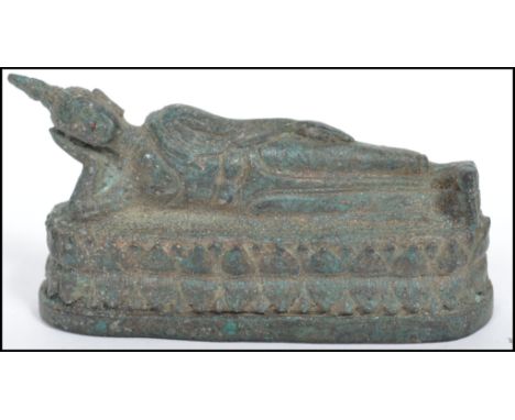 A 19th century bronze Buddha modelled in a reclined position raised on a oval plinth base. Measurements: 4 cm high, 9 cm wide