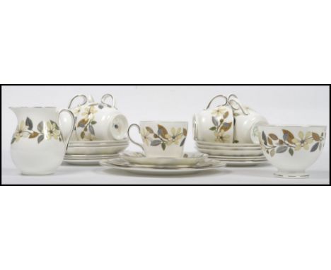 A Wedgwood Bone China seven person tea service in a floral design, to include cups, saucers. creamer, sugar bowl etc. Stamped