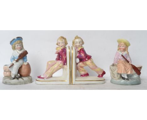 A pair of Victorian ceramic novelty bookends having children pushing and pulling along with a pair of spill vases with cerami