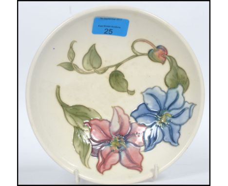 A mid century Walter Moorcroft ceramic bowl of open form being tube lined and painted with flowers on a white ground. Green W