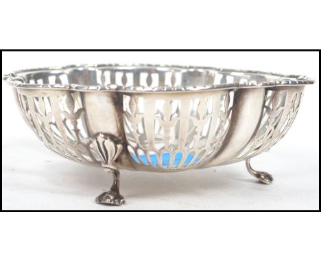 A 20th century hallmarked silver bowl raised on tripod cabriolet legs with pierced window sides and a scalloped rim. Hallmark