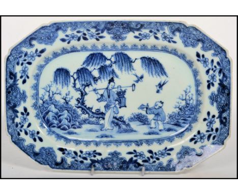 A 19th century Chinese blue and white ceramic charger decorated with stylised border and a central panel of a young boy offer