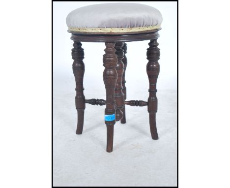 Victorian carved walnut revolving piano stool standing on a turned pillar and tripod base. Measures 92cms by 34cms  