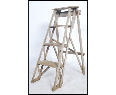 A vintage 20th century Industrial trestle sides wooden step ladder of a-frame style with stepped side and trestle ends. Ideal