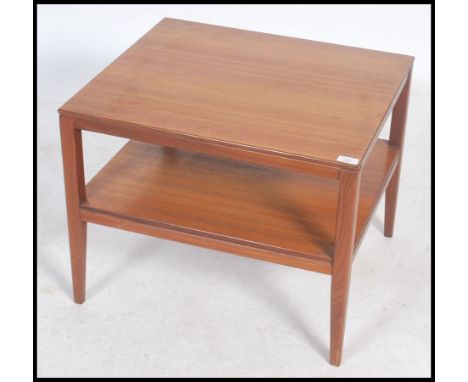 A stunning retro 20th century Danish square teak wood coffee table raised on square tapering legs united by a single under ti