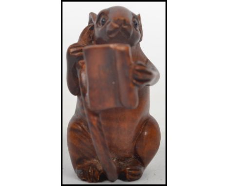 A vintage Oriental carved netsuke entitled ' smart mouse ' depicting a mouse holding its tail reading a book. measures 5 cm h