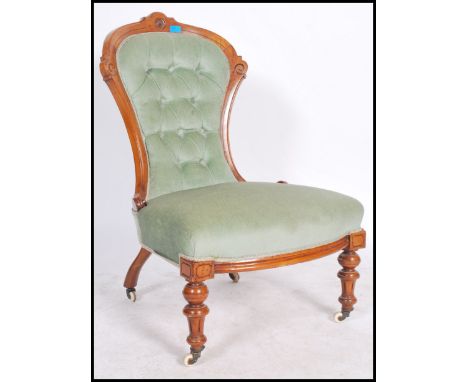 A Victorian walnur armchair being raised on turned reeded legs with ceramic castors having green velour upholstered chair wit