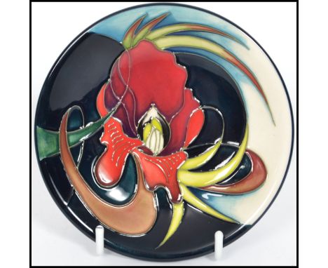 A Moorcroft Trial Piece ceramic tube lined coaster pin dish decorated in The Satin-flower pattern on a black blue and white g