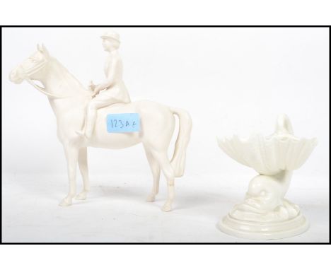 A Beswick white ceramic figurine of a horse and rider together with a white parian glaze Royal Worcester table salt of a carp