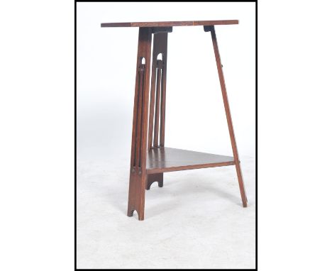 An Arts and Crafts, Liberty and Co style oak tripod occasional table, the three splayed legs fret carved with teardrop motifs