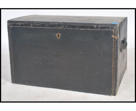 A vintage angled early 20th century car trunk with sloping front and carrying handles to the side, finished in black rexine. 