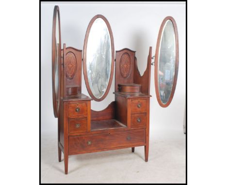 An Edwardian mahogany inlaid batwing dressing table being raised on square tapered legs with brown ceramic castors having a s