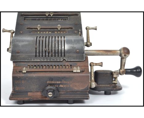 A vintage 20th century pressed metal industrial German Brunviga Nova 13Z portable adding machine raised on stub feet with cra