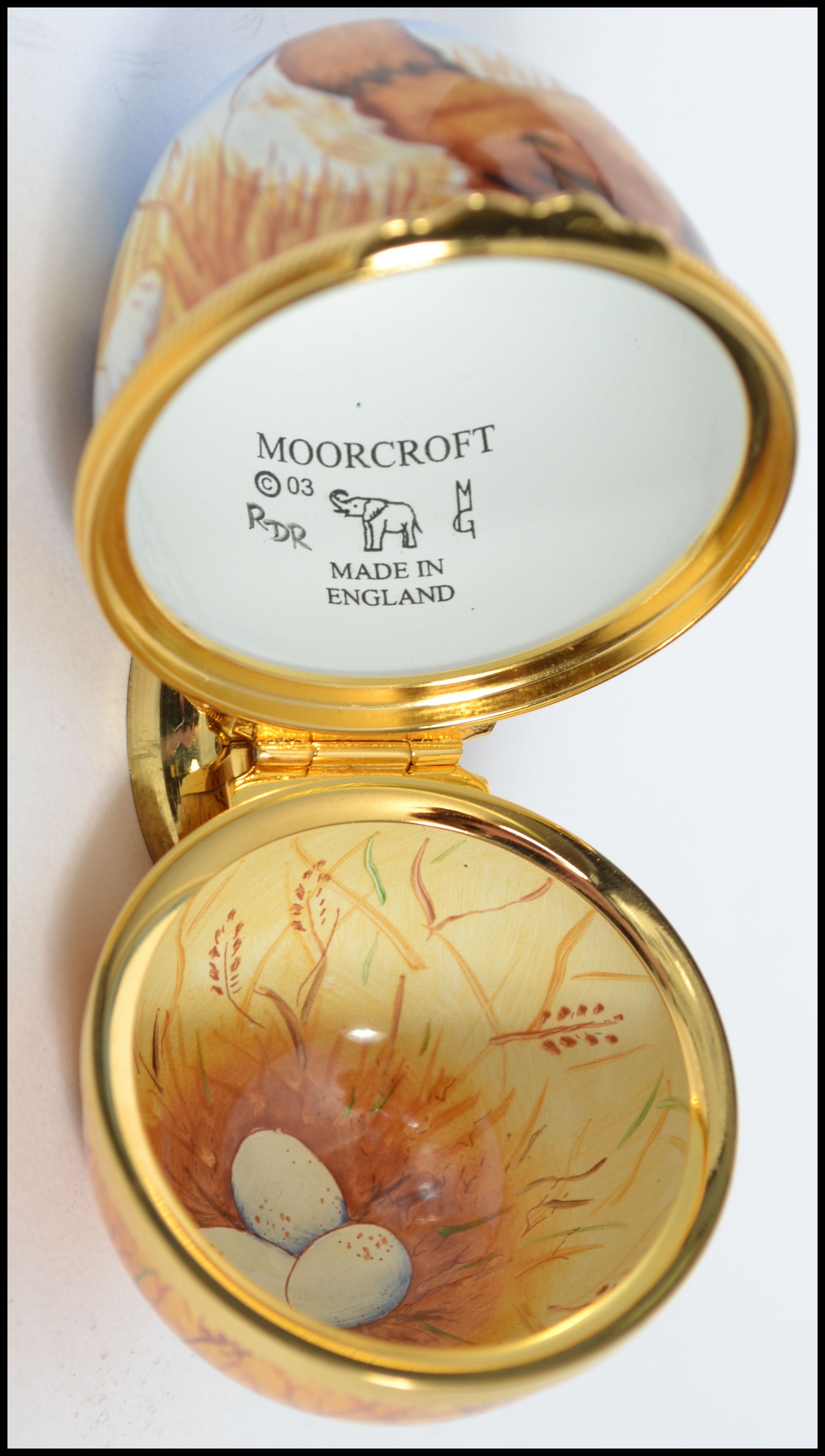 A Moorcroft painted enamel on copper trinket box in the form of an egg ...