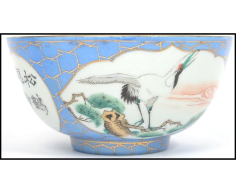 A believed 19th century Oriental ceramic bowl having a blue and gilt ground with white cartouche panels depicting cranes with