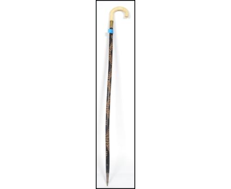A 19th century Victorian walking stick cane having a shaped ivory handle with ebonised and carved shaft with brass collar. Me