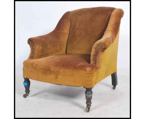 A Victorian mahogany armchair, upholstered with button fabric, on turned legs with ceramic castors 