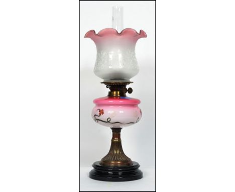 A 19th century brass and coloured stained glass cranberry glass reservoir oil lamp. Black ceramic terraced base with brass wh