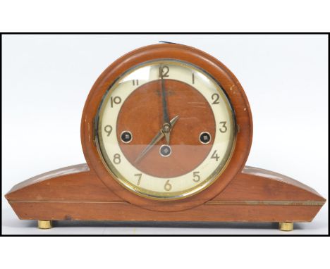 A vintage art deco style wooden cased mantle clock by Bentima having an circular face with sloped shoulders having a German 6