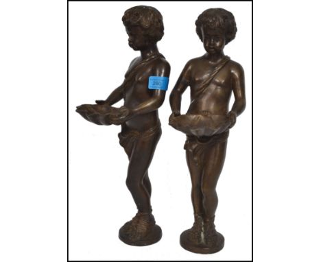 A pair of believed 19th century Victorian bronze figurines in the form of page boys holding large clams with detailed feature