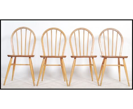 A set of four 20th century Ercol ' Windsor ' light elm and beech stick and hoop back dining chairs, applied labels to rear of