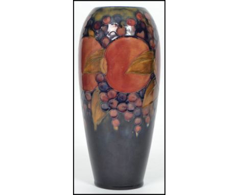 An early 20th century William Moorcroft hand painted ceramic tubelined vase decorated in the famous pomegranate and grape pat