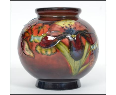 A mid century Walter Moorcroft globular ceramic vase painted and tube lined with flowers. The bulbous body raised on a circul