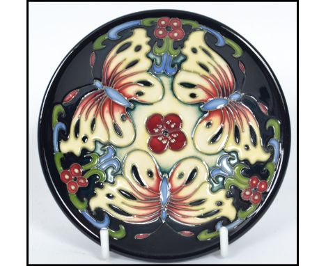 A Moorcroft ceramic tube lined coaster pin dish decorated in the Burley Butterfly pattern complete in the original box with p