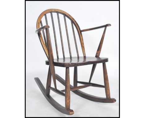 A mid 20th century Ercol rocking chair having cc utility mark raised on box rockers with rail back. Measurements 74cms high 