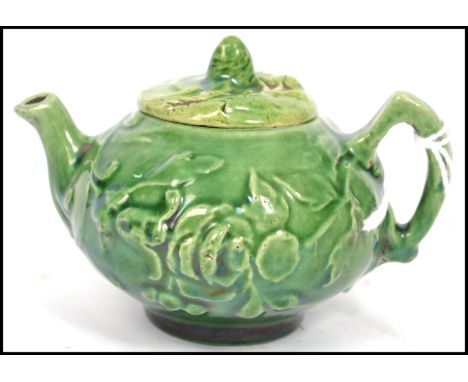 A 19th century Oriental ceramic Yi Xing tea pot of globular form having a green textured naturalistic decoration. Measurement