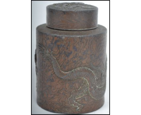 An early 20th Century Chinese tea caddy of small proportions in metal with detailing of a dragon along with writing, notation