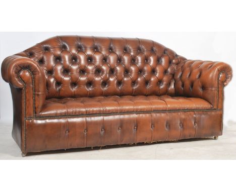 An antique style Chesterfield sofa settee in tan brown leather being button back to the seat and back rest. Raised on castors