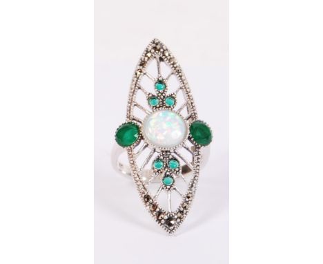 A ladies contemporary silver Art Deco style ring being set with a central opal stone surrounded by emeralds