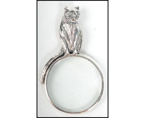 A contemporary decorative ladies silver necklace pendant in the form of a magnifying glass having a cat adorned finial