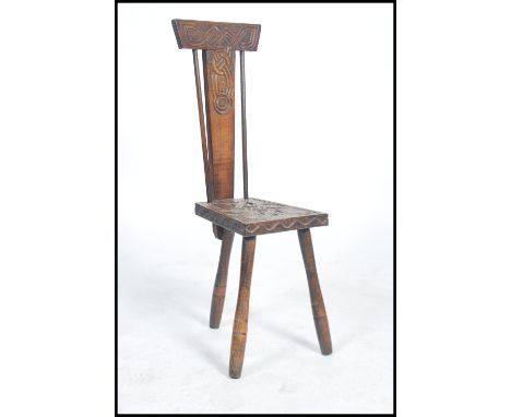 A 19th century Victorian Welsh spinning chair raised on tapering tripod legs with Celtic knot carved seat twin rail back with