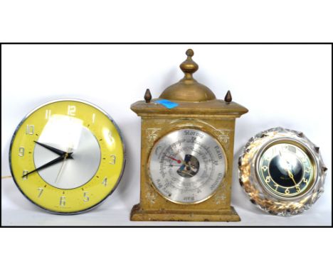 A Majik Russian crystal clock along with a Metamec yellow and chrome circular clock and a brass mantle clock shaped barometer