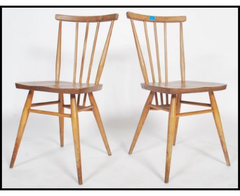 A pair of ercol 1970's stick back dining chairs in blonde model no 391. Measurements 80cms x 39cms x 40cms. 