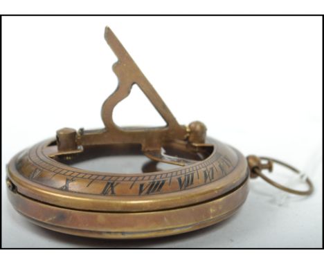 A 20th century brass cased compass of military design bearing notation to the verso together with applied sundial