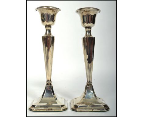 A matching pair of silver hallmarked silver candle sticks but each having different assay marks and makers mark. One stick wi