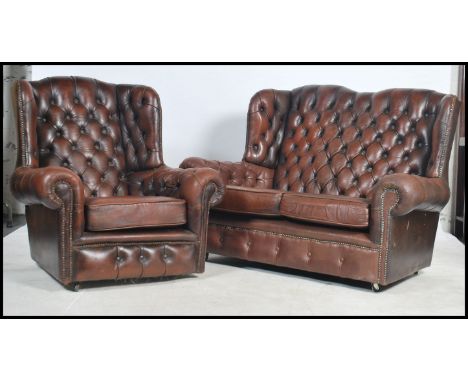 An antique style brown leather Chesterfield sofa settee having buttoned back leather scrolled arms and back rests together wi