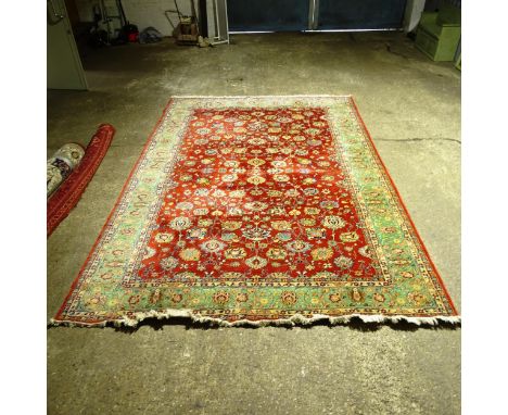 A red and green ground Persian design carpet, with floral symmetrical pattern, 423cm x 290cm (Viewing by appointment only as 