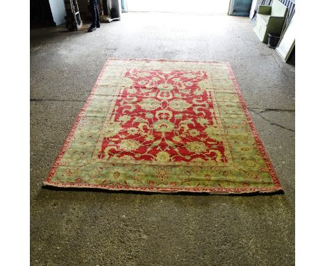 A red and green ground Persian design carpet, 352cm x 268cm (viewing by appointment only as this item is not on display in th