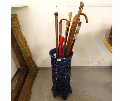 A blue painted cast-iron stick stand, H58cm, with 9 assorted parasols, walking sticks and shooting sticks (10) 