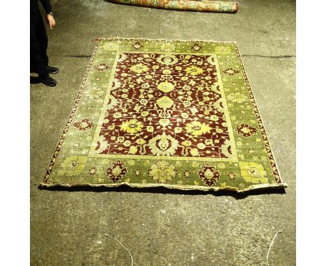 A green ground Persian design carpet, with a red and green border and red central lozenge, 300cm x 232cm (Viewing by appointm