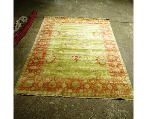 A large green ground Persian design carpet, with red border, 350cm x 270cm (Viewing by appointment only as this rug is not on